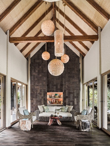 living room with a round chandelier overlooking a table with 3 ornated chairs