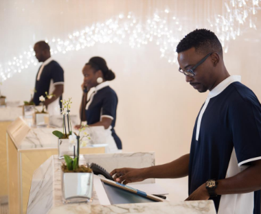 Three receptionists standing at desks