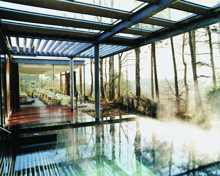 A steamy outdoor pool looking out onto a forest landscape