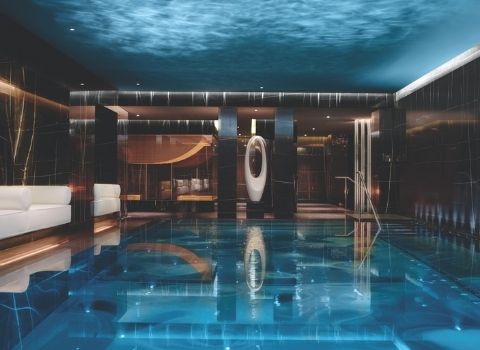indoor pool surrounded by dark marble walls